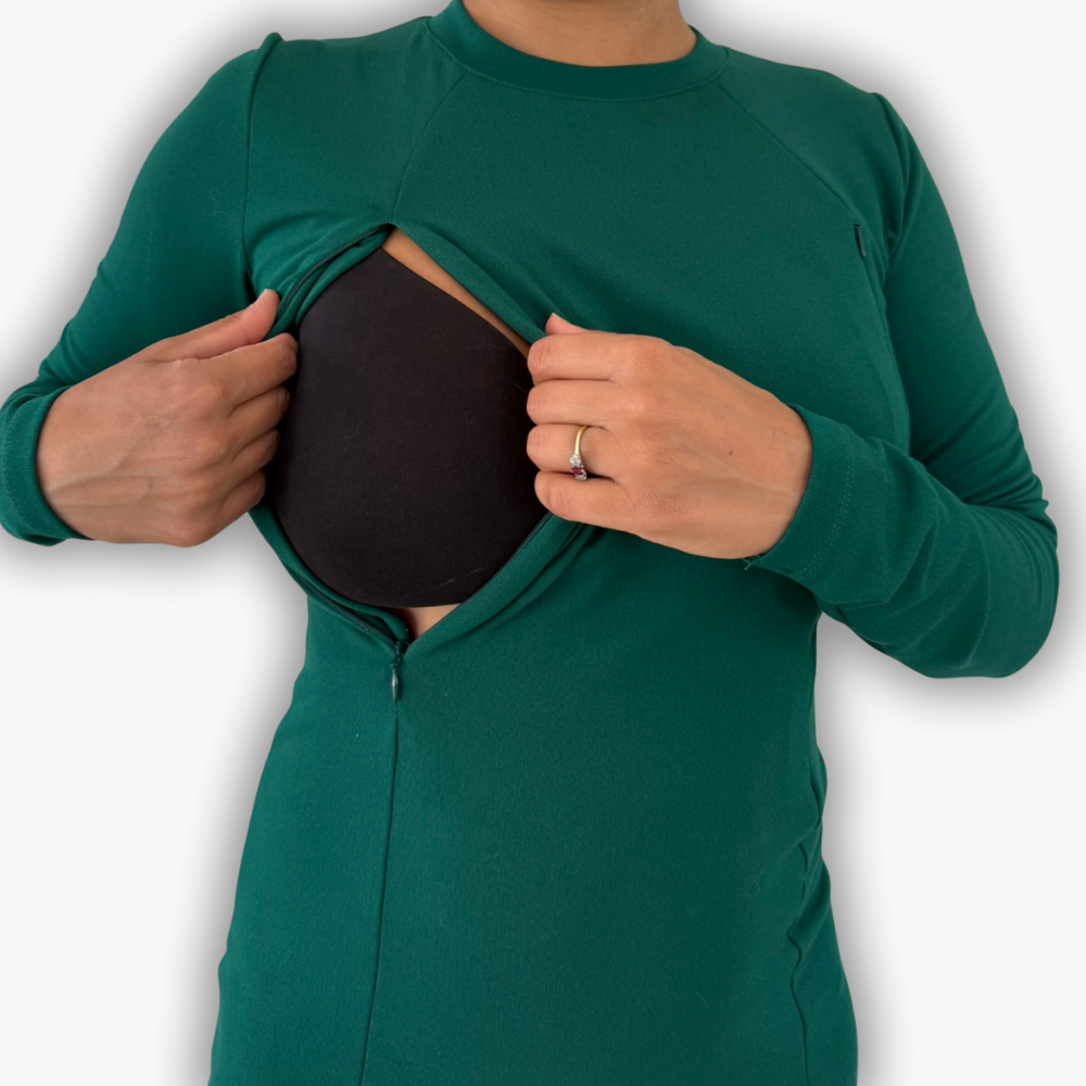 A woman demonstrating the easy zip breast access on her green nursing dress