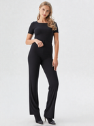 Woman wearing a black jumpsuit on a white background