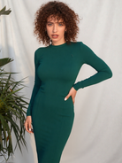 Woman wearing a stylish emerald green nursing dress